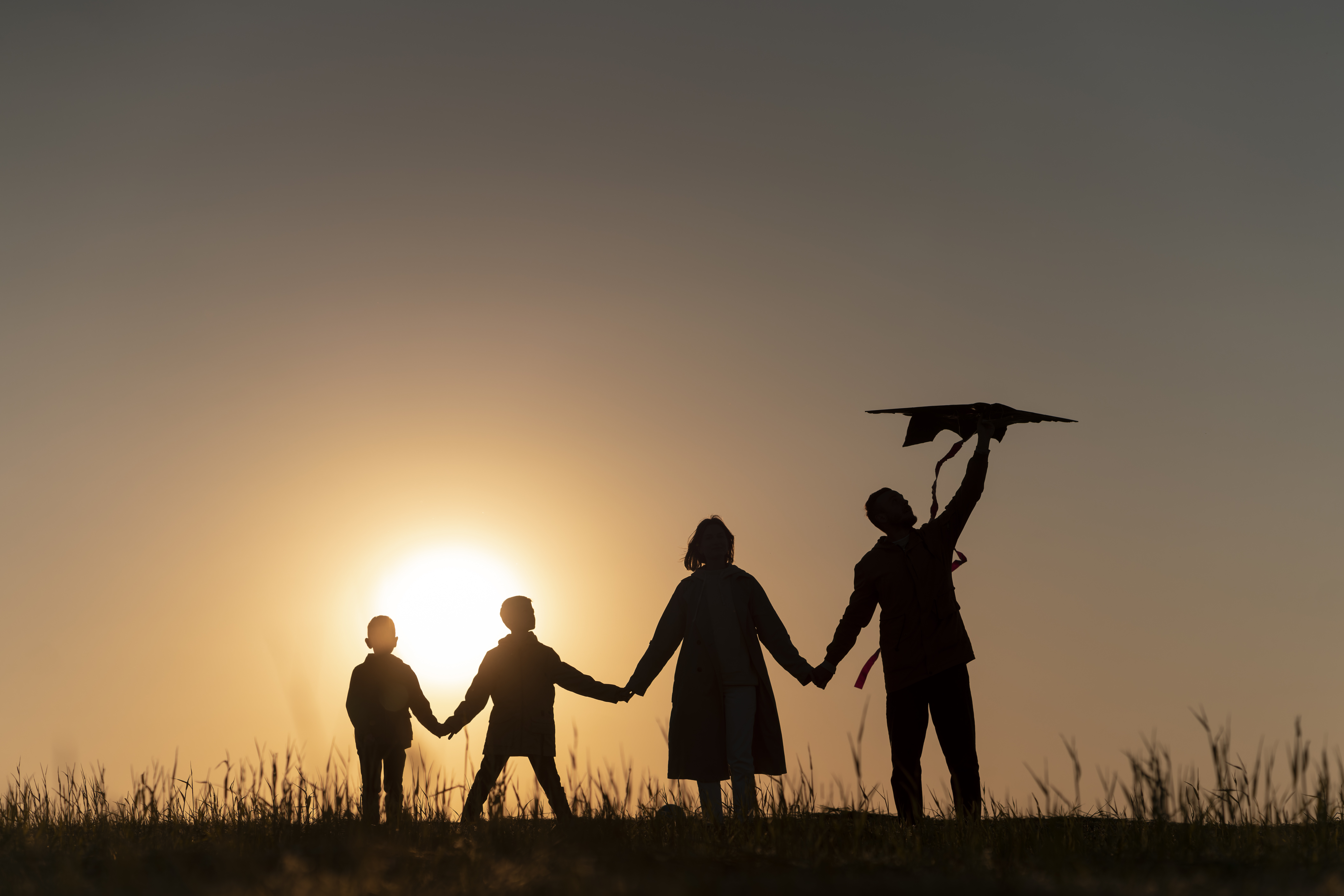 full-shot-family-silhouette-having-fun-sunset